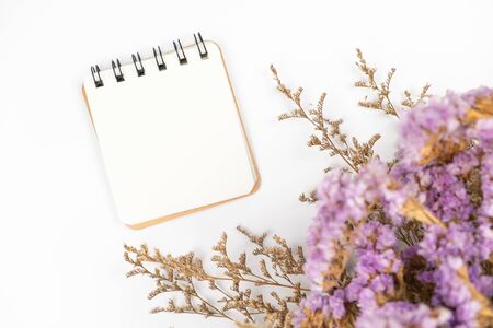 Top view of a blank paper note with a cute caspia and statice flower bouquet on white backgroundの写真素材
