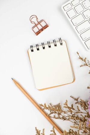 Top view of a blank paper note with pencil and a cute caspia flower bouquet on white backgroundの写真素材