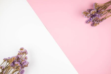 Top view of purple statice flowers bouquet on pastel pink and white backgroundの写真素材