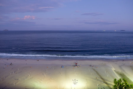 Night view of Copacabana beach during sunset in early evening, taken from the rooftop of a hotel,...