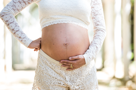 Detail of pregnant woman holding belly in ethereal scenarioの写真素材