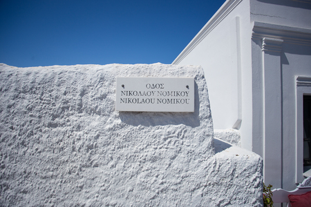 marble sign in greek, in traditional white washed wall bathed by light and shadow in Traditional Santorini house. Santorini, Greeceの写真素材