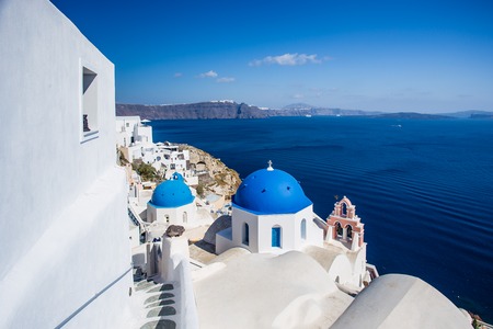 Gourgeous view from white walled town of Oia in Santorini, Greece, with ocean, cliffs and caldera of Santorini in the backgroundの写真素材