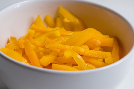 top view of sliced yellow bell pepper on white counter top.の写真素材