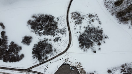 Aerial top view of a foot path in winter , surrounded by snow. Kanata neighborhood can be seen in the background. Ottawa, Ontario, Canadaの写真素材