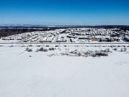 Aerial of the Kanata neighborhood in winter. Suburbian houses next to a large area covered with snow. Kanata, Ottawa, Ontario, Canada.の写真素材