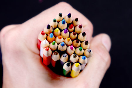 Assortment of coloured pencils with shadow on white black background