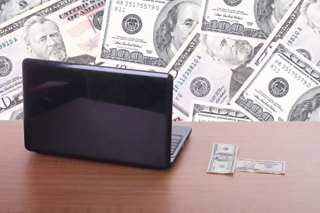 money flying and pouring out from a notebook computerの写真素材