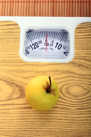 yellow apple and measure tape above the balanceの写真素材