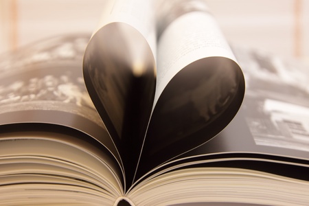 book pages open heart-shaped, with its shadowsの写真素材