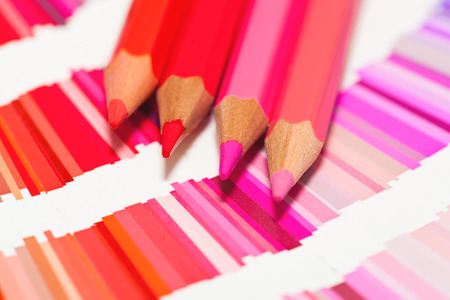red and pink colored pencils and color chart of all colorsの写真素材