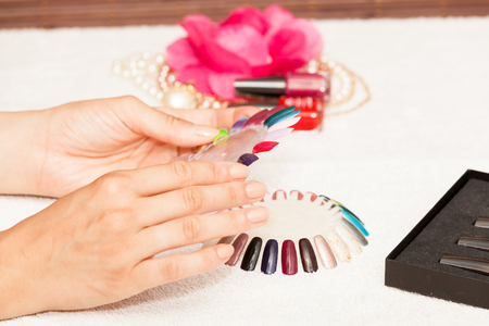 Hands of a woman who chooses the color of her nail polishの写真素材