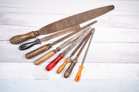 Sets of different wood rasps of different sizes in the middle of an old wooden floor background. top...