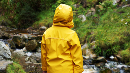Child in Yellow Rain Coat watches the River