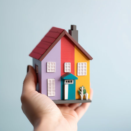 House model in hand on a blue background. Real estate concept.の素材