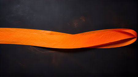 Orange ribbon on a black background. Horizontal image with copy spaceの素材