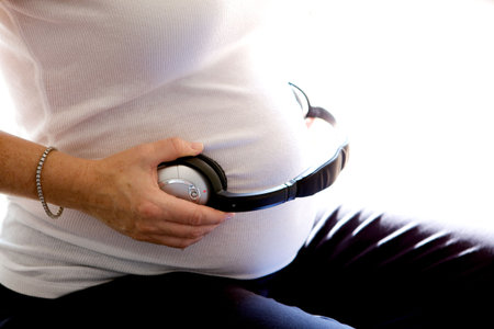 A mother playing music to the unborn baby in her bellyの写真素材