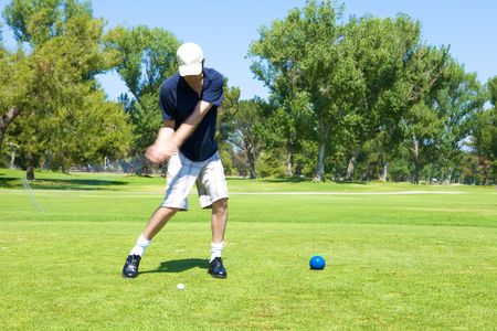 A golf playing swinging the ball with precisionの写真素材