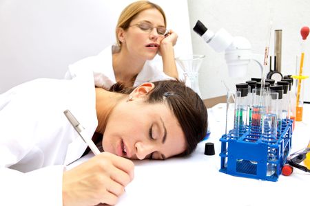 Two female scientists Asleep in a labの写真素材