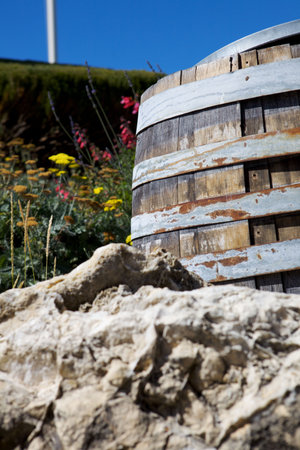 A Wine Barrel at a Vinyard With Flowers