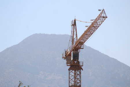 Construction crane on the background of the mountains. View from below.の写真素材