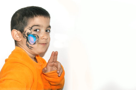 Beautiful kid with face painted with a spiderの写真素材