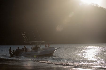 Enjoy the serene beauty of a boat gliding on calm waters at sunset. Ideal for travel and relaxation themes, this image captures tranquility and peacefulness. Tamarindo, Costa Ricaの写真素材
