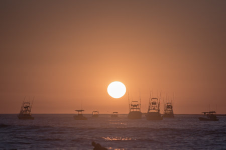 Enjoy the serene beauty of boats gliding on calm waters at sunset. Ideal for travel and relaxation themes, this image captures tranquility and peacefulness. Tamarindo, Costa Ricaの写真素材