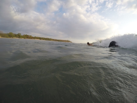 Tamarindo, Costa Rica - People surfing off the beachの写真素材