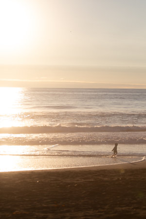Sunset in the background with people in silhouette, outdoor, kid playingの写真素材