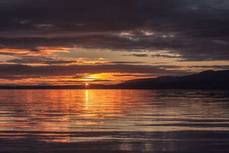 Sunset over the Pacific. Golden sunset lighting up the ocean waves along the coast, with vibrant sky colors and relaxing beach atmosphere.の写真素材