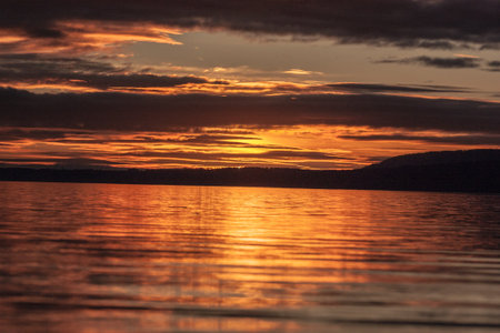 Sunset over the Pacific, Chile. Golden sunset lighting up the ocean waves along the coast, with vibrant sky colors and relaxing beach atmosphere.の写真素材