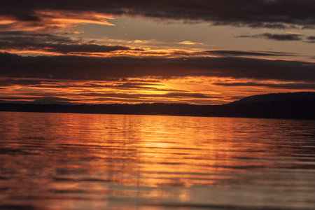 Sunset over the Pacific. Golden sunset lighting up the ocean waves along the coast, with vibrant sky colors and relaxing beach atmosphere.の写真素材