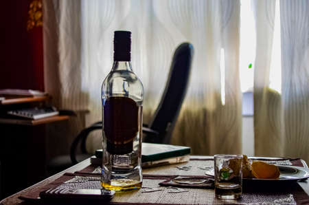bottle of whiskey in the office on a coffee table close-upの写真素材