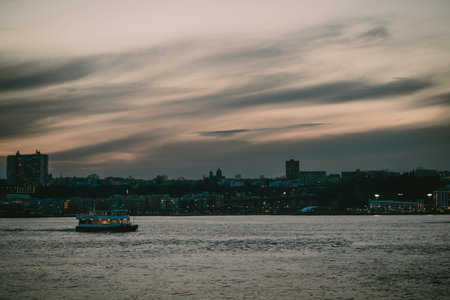A boat floats on water with a city in the backgroundの写真素材