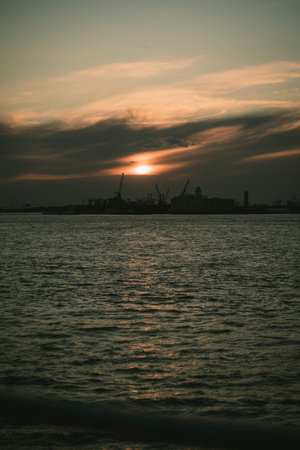 A sunset over water with a city in the backgroundの写真素材