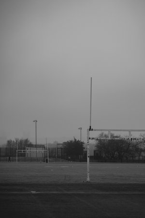 A black and white photo of a football field with a goal postの写真素材