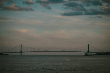 A bridge over water with a cloudy sky in the background