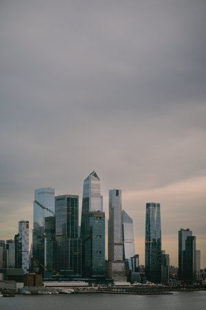 City skyline with cloudy sky and water in the foregroundの写真素材