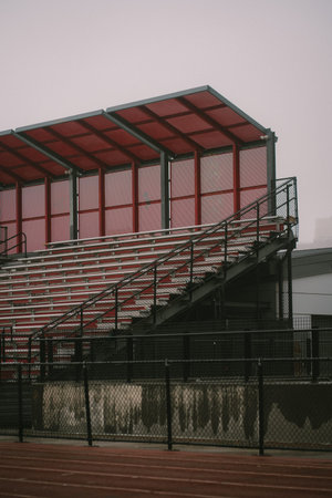 A large stadium featuring bright red seats and a striking red roofの写真素材