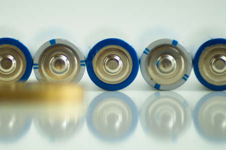 set of batteries, coins and light bulb on white backgroundの写真素材