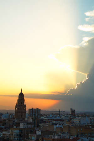 Spectacular sunset over the city of Murcia with the cathedral tower in the foregroundの写真素材