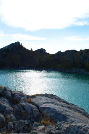 Beautiful landscape of the Embalse de la Cierva in Murcia with the reflection of the sun in the water with gentle wavesの写真素材