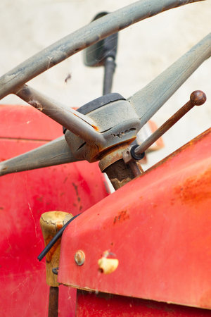 Old, dirty and polluting abandoned red tractor