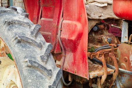 Old, dirty and polluting abandoned red tractorの写真素材