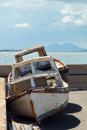 Old abandoned boat on the dock of the fishing portの写真素材