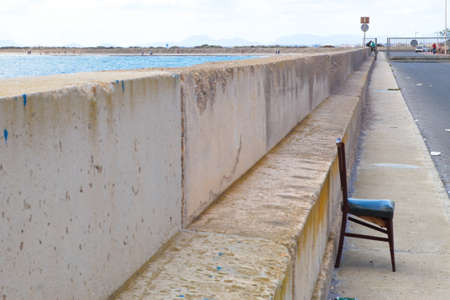 A deteriorated and isolated chair inside the fishing portの写真素材