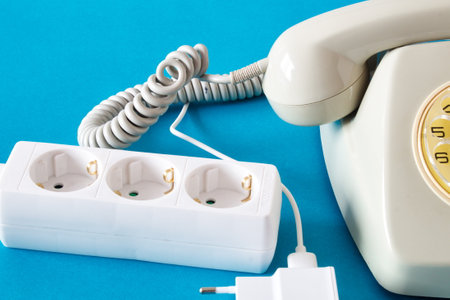 Old technology telephone connected to the electrical network through a plugの写真素材