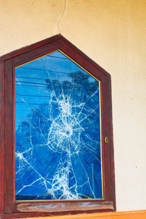 Glass broken into a thousand pieces by a bullet impact