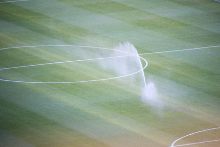 Soccer field grass irrigated for maintenanceの写真素材